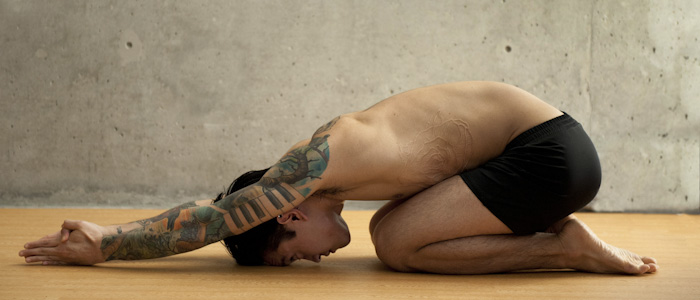 Handsome Man with Tattoos doing Half Tortoise Pose