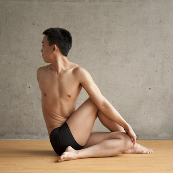 Man doing spinal twisting pose Bikram Yoga Pose